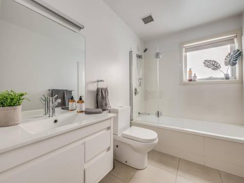 霍巴特Marina View Apartment的白色的浴室设有卫生间、浴缸和水槽。