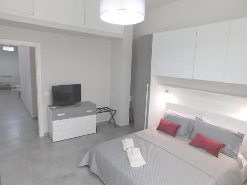 巴勒莫Palermo Relax的一间卧室配有一张带红色枕头的床和一台电视。