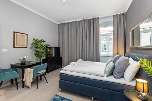 里耶卡Apartments Carpathia的一间卧室配有蓝色的床和桌椅