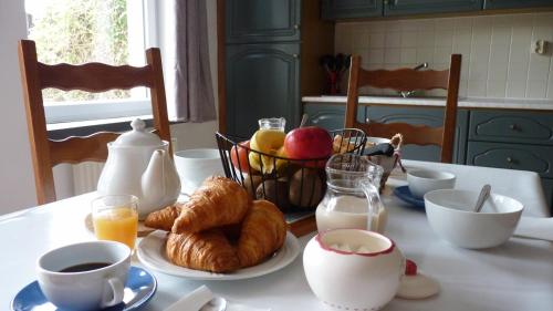 滨海圣布里阿克Gite la Ville Brunet的一张桌子,早餐包括羊角面包、咖啡和鸡蛋