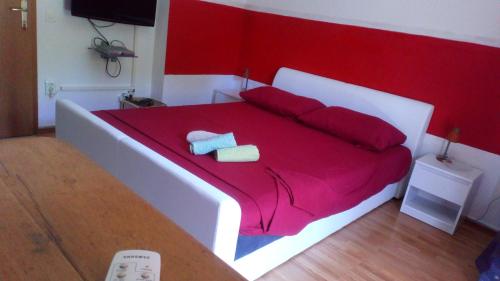 苏佩塔尔Rooms & Studio的一张红色和白色的床,上面有两条毛巾