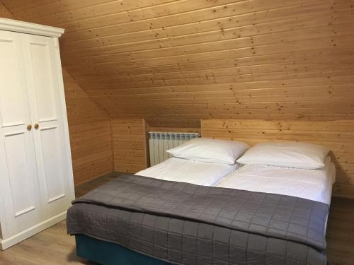 达布基Wygodny murowany domek- NOWY的木制客房内的一间卧室,配有一张床