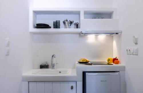 FiropótamosMilinon Suites的白色的小厨房设有水槽和水槽