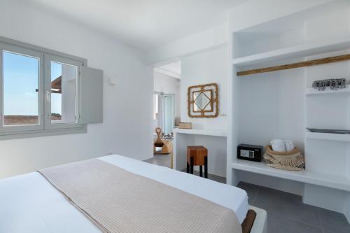 易莫洛林Bianco Diverso Suites的白色的卧室设有床和窗户