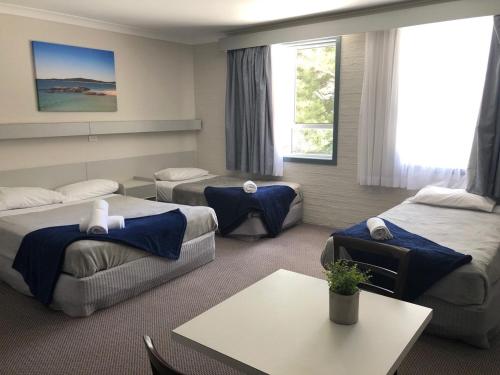 西南岩海风沙滩酒店的酒店客房设有三张床和一张桌子