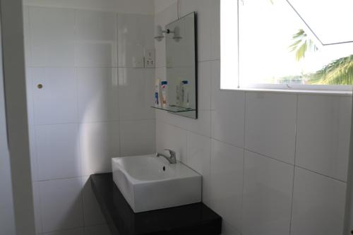 波隆纳鲁沃曼内尔旅馆的白色的浴室设有水槽和窗户。