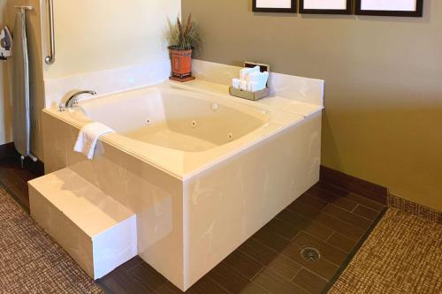 大学城德克萨斯大道舒适套房酒店的浴室内设有大型白色浴缸。