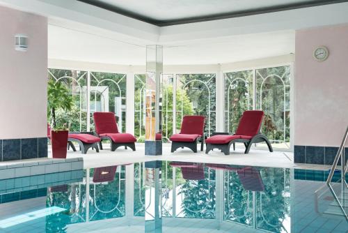 巴特拉尔Hotel Pieper-Kersten的大堂设有红色椅子和游泳池
