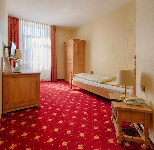 明登科隆帕丽泽咖尼酒店的酒店客房配有一张床、一张桌子和一张桌子。