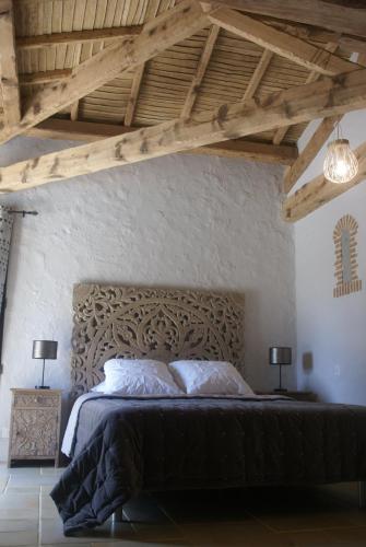 Le BoupèreVILLA PIETRA的一间卧室配有一张大床和木制床头板