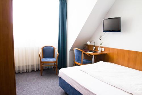 齐恩多夫祖尔科夫酒店的一间卧室配有一张床、一张书桌和一台电视。