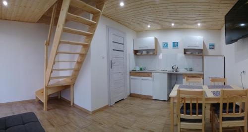 尤斯托尼莫斯基Domki letniskowe i pokoje u Katarzyny的一间厨房和用餐室,在一间房间内拥有螺旋楼梯