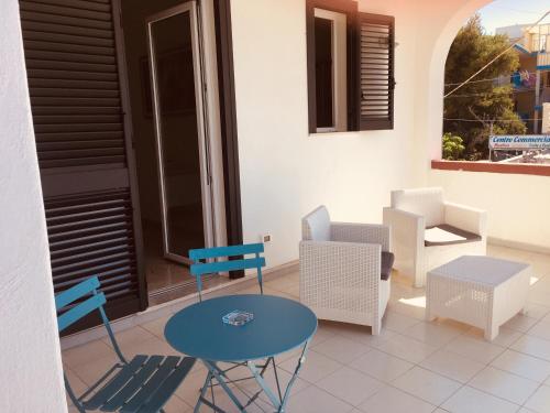 普尔萨诺Villa Iavernaro的庭院配有椅子和蓝色的桌椅