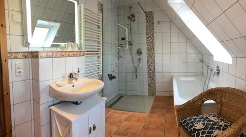 青斯特Zingst Haus Hugo的浴室配有水槽、淋浴和浴缸。