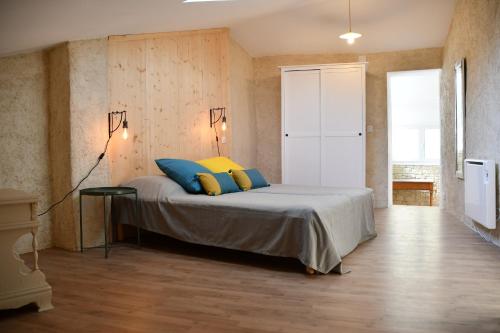 马洛塞讷Le pigeonnier的一间卧室配有蓝色和黄色枕头的床