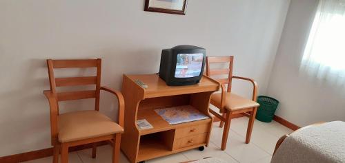 费罗尔Hostal El Cairo的一张桌子上摆着两把椅子的电视机