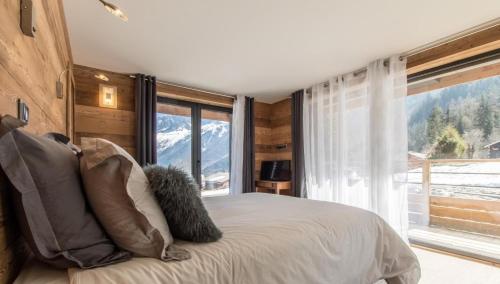里雾诗chalet des grands bois的一间卧室设有一张床和一个大窗户