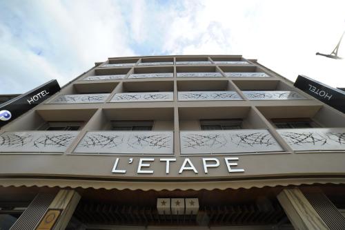 圣弗卢尔Cit'Hotel Grand Hotel L'Etape的一座白色的大建筑,上面写着字母