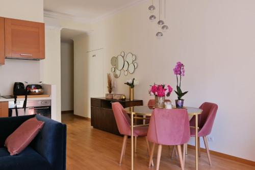 尼斯Nice Apartment Roses & Ivy, Rue du Congres的客厅配有带粉红色椅子的桌子