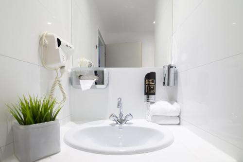 安特卫普Hotel National Antwerp的白色的浴室设有水槽和电话