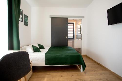 奥古斯图8 Jezior的一间卧室配有一张带绿毯的床