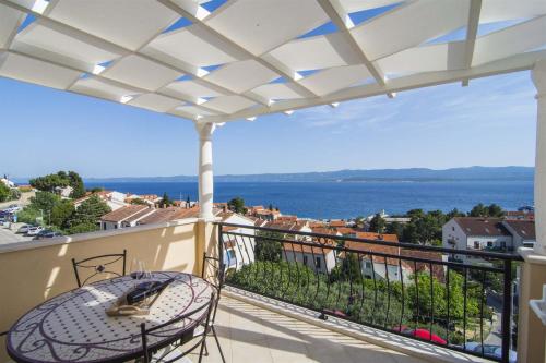 波尔Villa Marina - Sea view的阳台配有桌子,享有水景