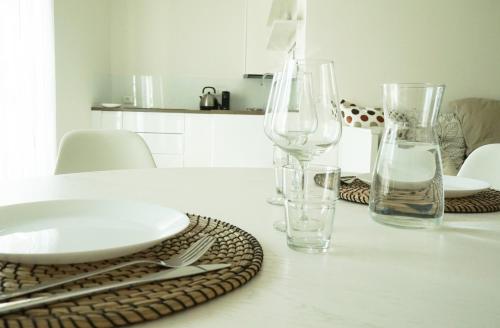 贝加莫Casa Sisu - Apartment的一张带玻璃杯和盘子的白色桌子
