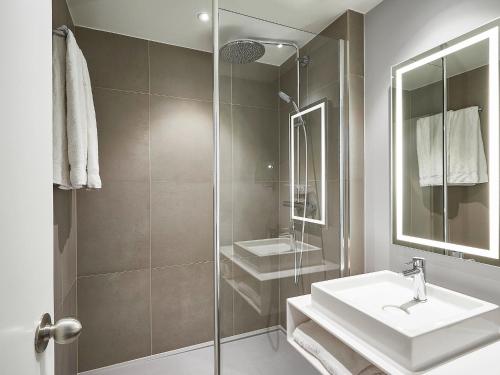 伊普尔诺富伊珀尔中心酒店的白色的浴室设有水槽和淋浴。
