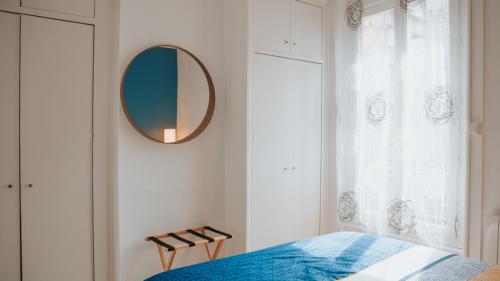 维勒班Appartement écologique - Proche Métro Charpennes的卧室配有一张床,墙上设有镜子