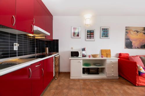 科斯塔特吉塞The Colors House, 639 Private Apartment的厨房配有红色橱柜和红色沙发