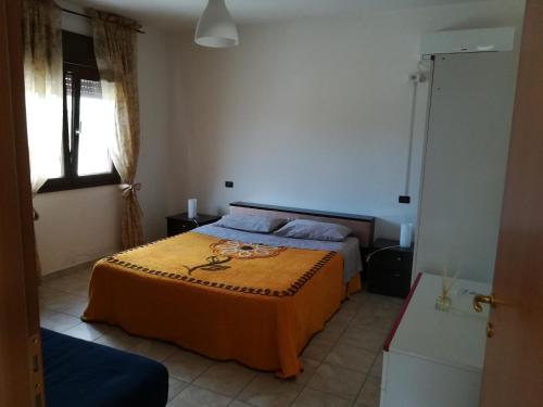 贝瓦尼亚圣彼得Villa Marina的一间卧室配有一张带橙色毯子的床