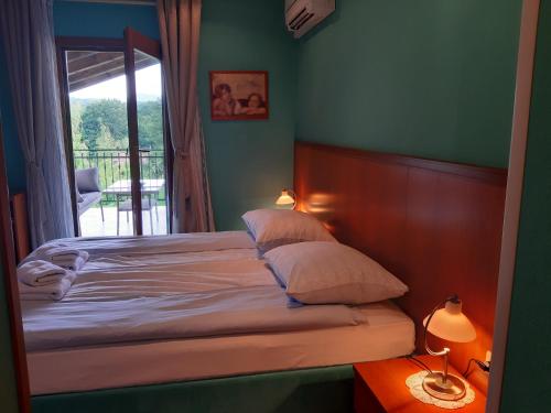 Šempas勒班旅馆的卧室内的一张带两个枕头的床和一个窗户