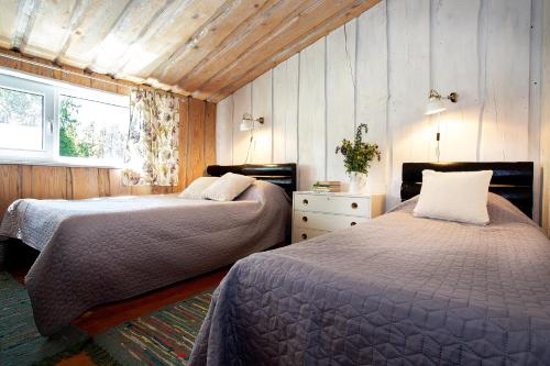 Haanja米尚度假屋的一间卧室设有两张床和窗户。