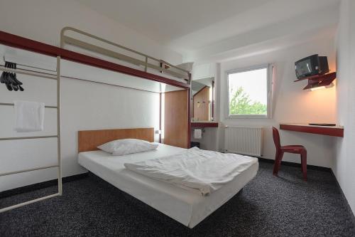 波鸿波鸿经济型酒店的一间卧室配有双层床和书桌