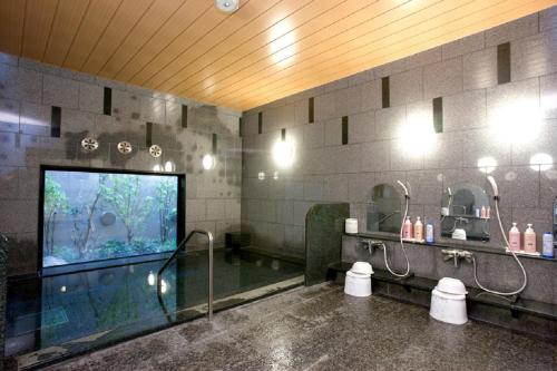 延冈市延冈站前茹特酒店的带淋浴的浴室和大屏幕电视