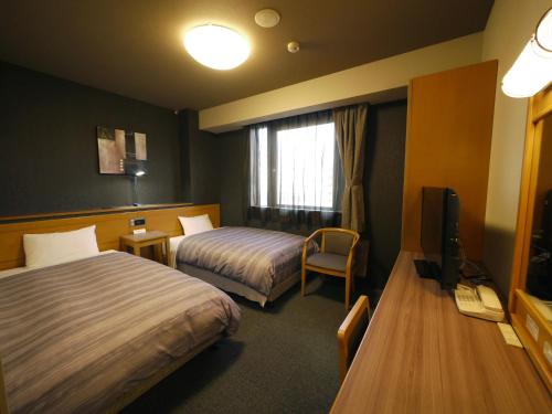 札幌札幌奇塔约行程酒店的酒店客房设有两张床和电视。