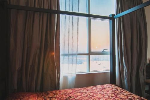 阿吉曼Exclusive Creek Bay Apartment的一间卧室设有一张床和一个大窗户