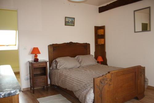 Druy-Parigny乐皮提特名古特度假屋的一间卧室配有一张床和一个带灯的床头柜