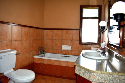 纳库鲁纳库鲁湖山林小屋的浴室配有卫生间、盥洗盆和浴缸。