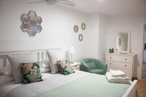 阿尔么丽亚Apartamento Reyes Catolicos的一间卧室配有一张床和一把绿色椅子