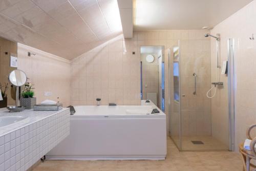 恩舍尔兹维克First Hotel Statt Örnsköldsvik的白色的浴室设有浴缸和淋浴。
