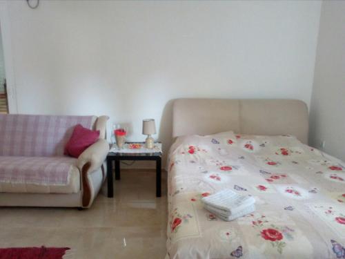 蒂瓦特Apartman Strahinja的一间卧室配有一张床、一张沙发和一张桌子
