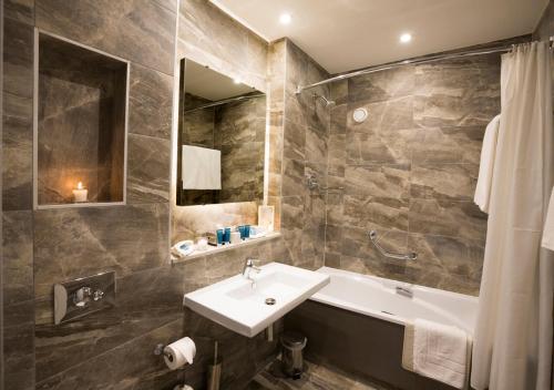 米德尔顿米德尔顿公园酒店的浴室配有盥洗盆和浴缸。