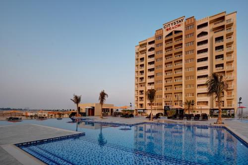 拉斯阿尔卡麦City Stay Beach Hotel Apartments - Marjan Island的大楼前设有游泳池的酒店
