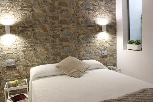 加尔达尔Gáldar, habitación privada en la playa的一间卧室设有一张床和石墙