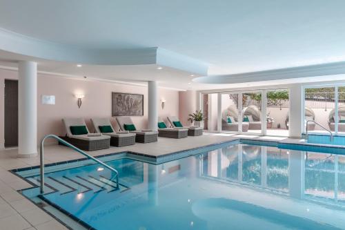 梅拉诺皮耶西那万姆斯古司帕克酒店的一个带椅子和沙发的酒店游泳池