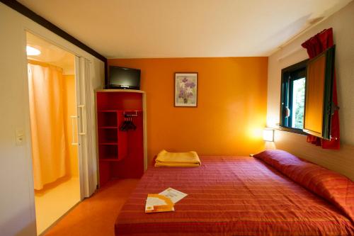拉沙佩勒圣梅曼西奥尔良 - 圣梅曼礼拜堂普瑞米尔经典酒店的一间卧室配有一张床和一个红色橱柜