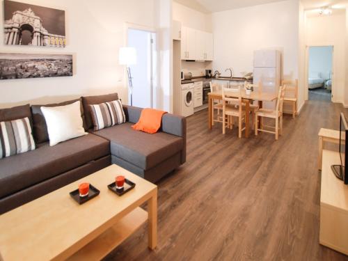里斯本蔡都索德里城市居住公寓酒店的客厅以及带沙发和桌子的厨房。
