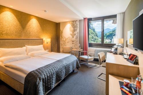 费尔德基希Best Western Premier Central Hotel Leonhard的配有一张床和一张书桌的酒店客房