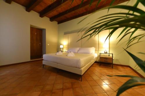 佩斯基耶拉德加达Osteria Luxury Apartments的卧室配有白色的床和植物